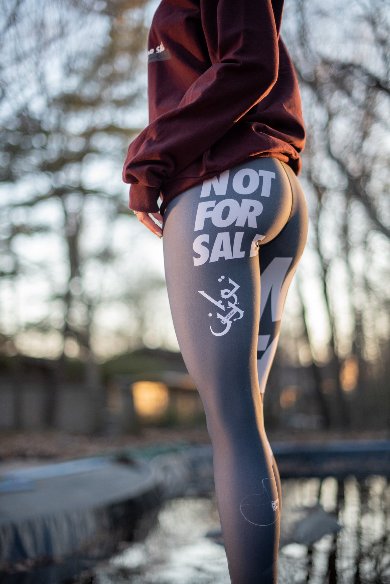 Person wearing leggings with 'Not for Sale' text in an outdoor setting